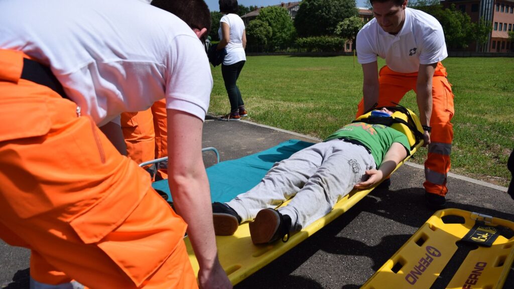 2 EMTs placing man on a stretcher
