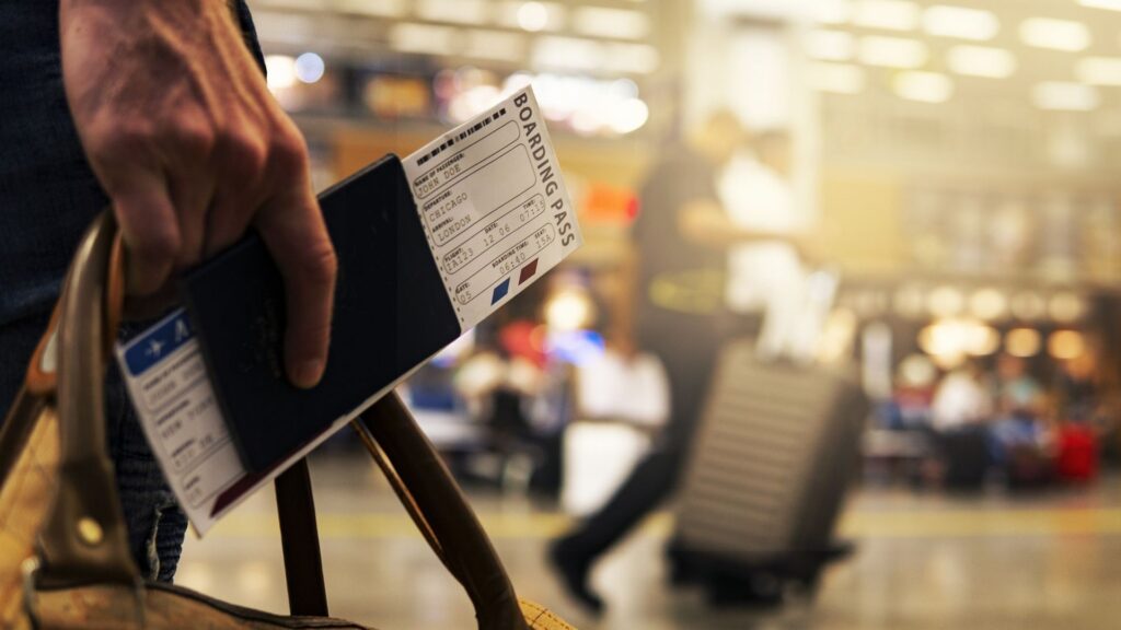 man holding airline ticket